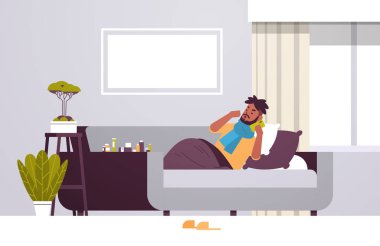 Hasta adam hapşırıyor sağlıksız Afro-Amerikalı fularlı adam soğuk grip virüsü hastalığından muzdarip tıbbi yardım için telefon arıyor modern oturma odası tam boy yatay oturma odası kavramı