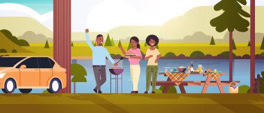 Arkadaşlar barbekü partisi konsepti veren Afro-Amerikan erkek ve kadınları ızgara sosisleri hazırlıyorlar. Park ya da nehir kıyısı manzarası düz yatay arka plan.