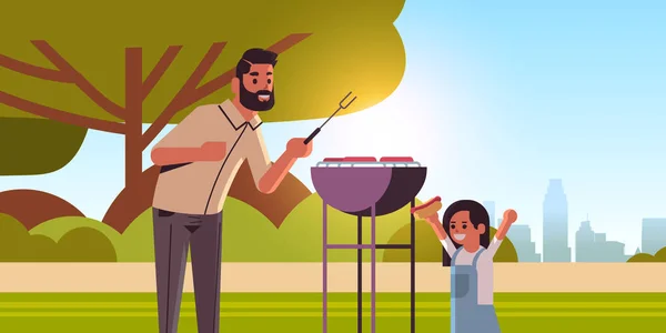 Padre e hija preparando perros calientes en la parrilla feliz familia divirtiéndose picnic barbacoa partido concepto verano parque paisaje fondo plano retrato horizontal — Archivo Imágenes Vectoriales