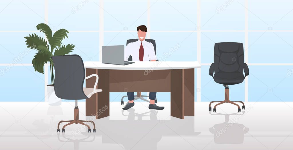 businessman sitting at workplace smiling business man working at laptop modern office interior horizontal