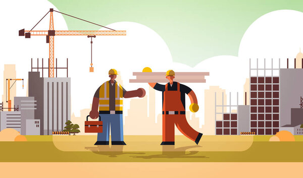 carpenter holding planks discussing with african american engineer workmen in uniform standing together building concept construction site background flat full length horizontal