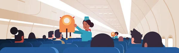 Hôtesse expliquant aux passagers comment utiliser le gilet de sauvetage en situation d'urgence agent de bord afro-américain concept de démonstration de sécurité avion moderne bord intérieur horizontal — Image vectorielle