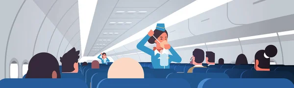 Стюардесса объясняет пассажирам, как использовать кислородную маску в чрезвычайных ситуациях бортпроводники концепция безопасности демонстрации современного самолета борту внутренних горизонтальных — стоковый вектор