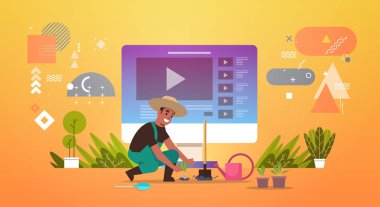 Çiftçi blogcu internetteki videocu vlogger Üniformasıyla sebze bahçesi tarım fidanlarına fideleri yerleştiriyor Tam uzunlukta yatay blog yazma kavramı