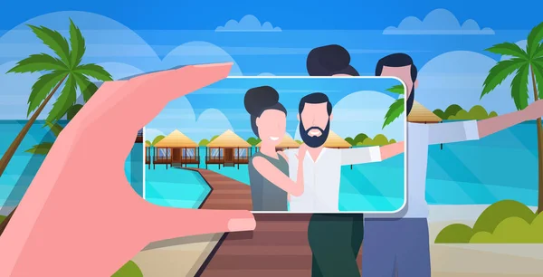 Blog yazarı akıllı telefon kamerasıyla mutlu erkek kadın yolcuların fotoğraflarını çekiyor cep telefonu bloglarında Vlog konsepti çekiyorlar yaz tatili deniz manzaralı arka plan portresi — Stok Vektör