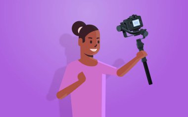 Kadın blogcu elinde kamerayla canlı yayın yapan sosyal medya ağı konsepti Afro-Amerikan flaması video portresi kaydediyor.