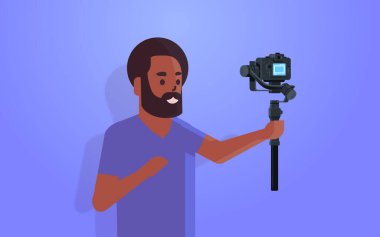 Adam blogcu elinde kamerayla canlı yayın yapan sosyal medya ağı konsepti Afro-Amerikan flaması video kaydediyordu. Fotoğraf portresini yatay çekiyordu.