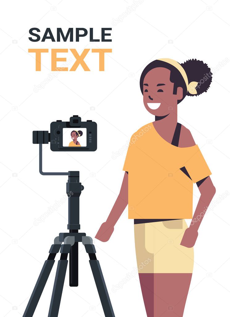 african american woman blogger recording video blog with digital camera on tripod live streaming social media blogging concept portrait vertical copy space
