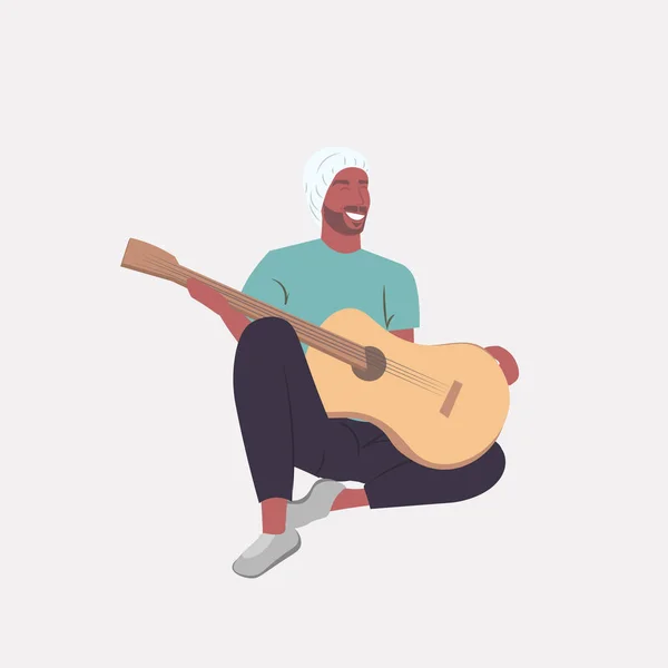 Muž hraje na kytaru africký americký kytarista sedí na podlaze po celé délce — Stockový vektor