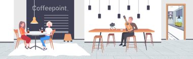 music blogger playing guitar live streaming musical blog concept african american man recording video using camera on tripod modern cafe interior horizontal full length
