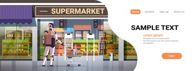 Market poşeti taşıyan robotlar el arabası alışverişini yapay zeka teknolojisi kavramını modern market süpermarketinin dış yüzeyinde tam boy fotokopi alanı ile yapıyorlar.