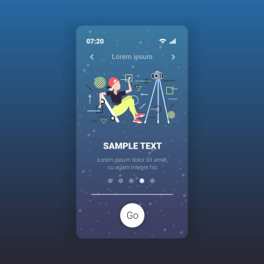 Kadın patenci kaykay blogcusu üç ayaklı sosyal ağ blog konsepti üzerinde kamerayla video kaydediyor. Tam boy akıllı telefon ekranı mobil uygulama kopyalama alanı