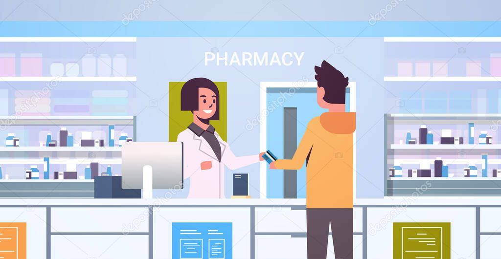 female doctor pharmacist taking credit card from male customer patient at pharmacy counter modern drugstore interior medicine healthcare concept horizontal portrait