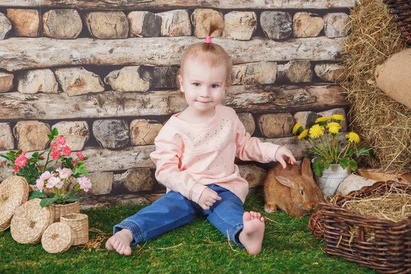 Bambina con un vivace coniglio marrone — Foto Stock