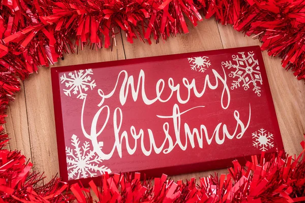 Frohe Weihnachten Text und Weihnachtsdekoration auf einem Holzrücken — Stockfoto