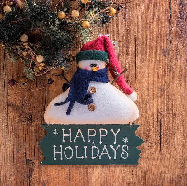木製の背景に幸せな休日のテキストとクリスマスの装飾雪だるま — ストック写真