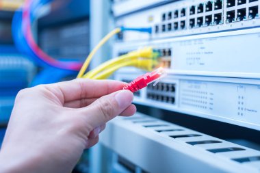 Dijital iletişim ve internet için fiber optik merkezi olan ağ sunucu odasında çalışan adam