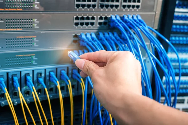 Dijital iletişim ve internet için fiber optik merkezi olan ağ sunucu odasında çalışan adam