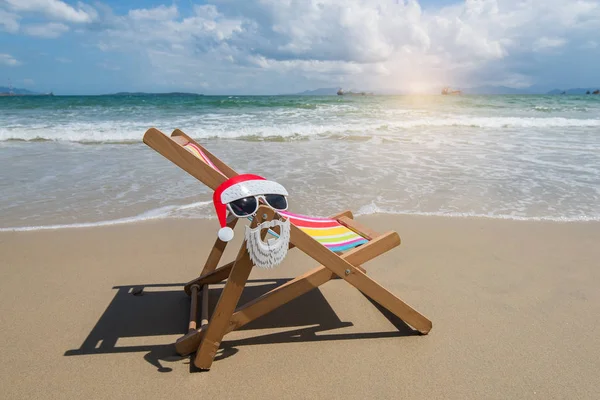 Deck chair at the tropical beach with Santa Claus sunglasses — Stock Photo, Image
