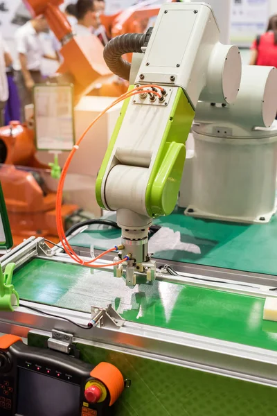 robot with vacuum suckers picks the mibile item from the conveyor in manufacture factory