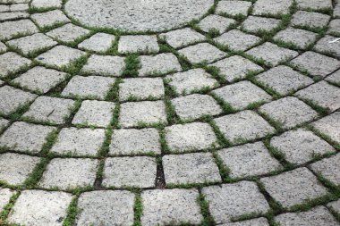 Yuvarlak taşlardan ve beton yoldan yapılmış kaldırım blokları.