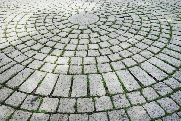 Paving blocks made of round stones and concrete path.