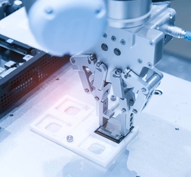 Robot kol bir bilgisayar çipi yüklüyor