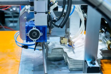 Vakumlu robotlu büyük bir baskı planının makineleri konveyörden kağıt seçer.