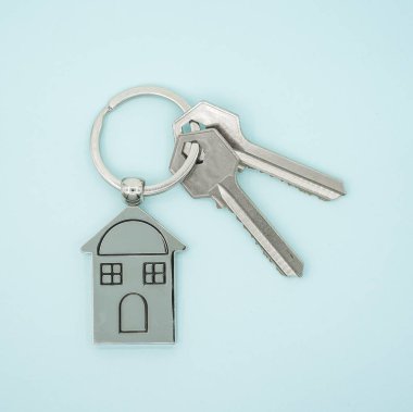 Mavi arka planda ev sembolü ve anahtar zinciri.