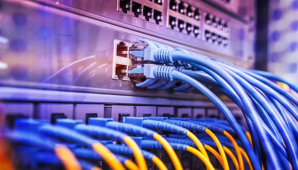 Estante del servidor con cables de cable de conexión a Internet azul y rojo —  Fotos de Stock