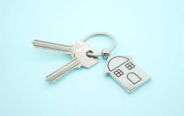 Llavero con símbolo de la casa y llaves sobre fondo azul, Real est — Foto de Stock