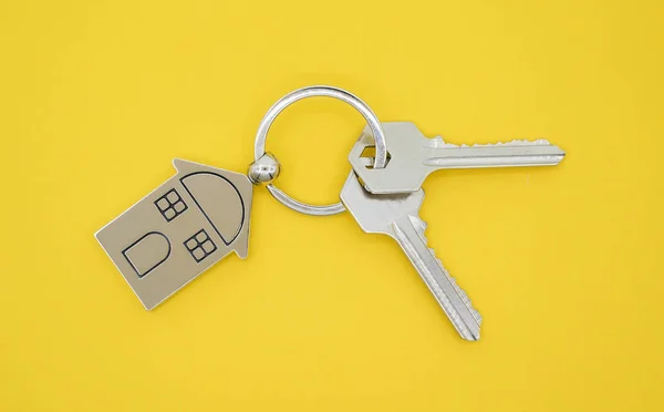 Chaveiro com símbolo da casa e chaves no fundo amarelo, Real e — Fotografia de Stock