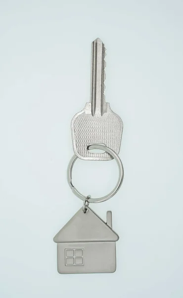 Přívěšek na klíče se symbolem domu a klávesami na bílém pozadí, Real es — Stock fotografie