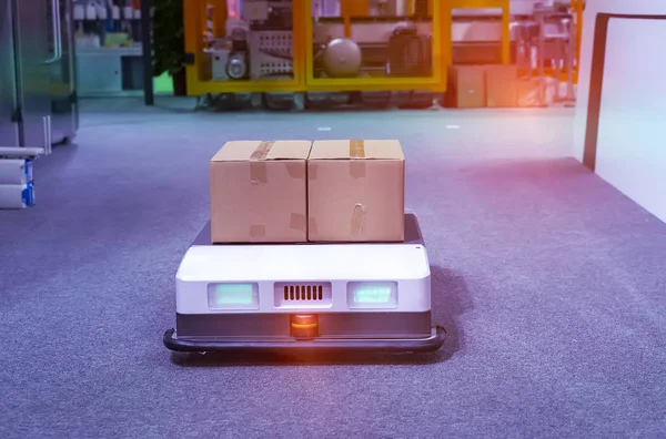 warehouse robot car carries cardboard box assembly in factory