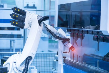 Robot kolu yapay zeka fabrikasının üretim bölümünde akıllıca çalışıyor.