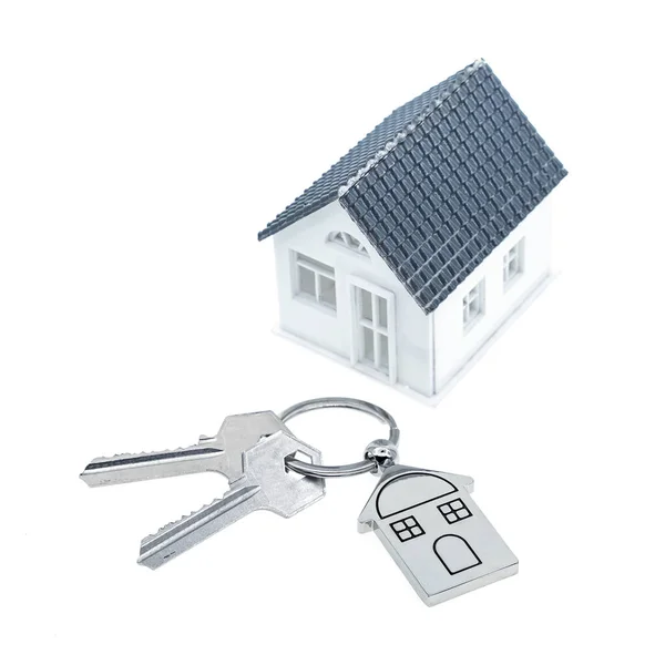 白い背景に家のシンボルとキーを持つキーチェーン 不動産コンセプト — ストック写真