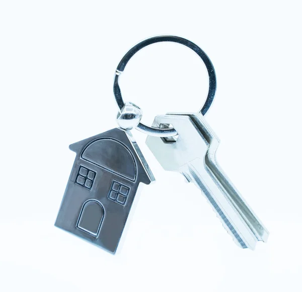 白い背景に家のシンボルとキーを持つキーチェーン 不動産コンセプト — ストック写真