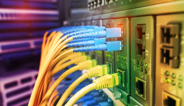 Fiber Optic cables connected to optic ports and UTP, Network cables connected to ethernet ports.