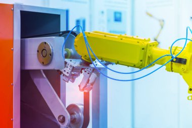 Üretim hattı arasındaki metal mekanizmalı kuyu parçalarını tutan robotik kol. otomotiv parçaları üretim süreci.