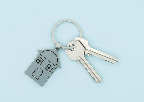 青い背景に家のシンボルとキーを持つキーチェーン 不動産コンセプト — ストック写真