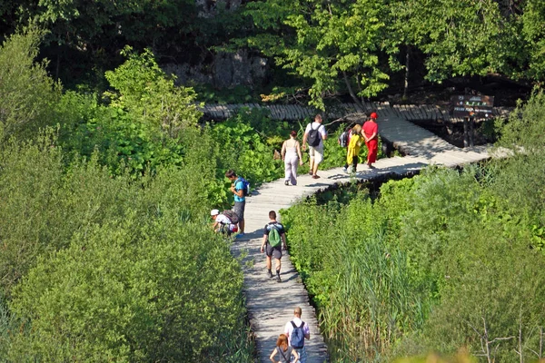 Turistas caminan por un sendero en los lagos de Plitvice — Foto de Stock