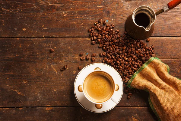 Tasse à café et haricots sur table en bois — Photo