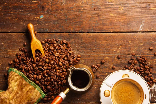 木桌上的咖啡杯和咖啡豆 免版税图库照片