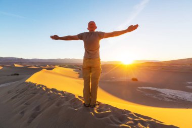 uzun yürüyüşe çıkan kimse Kum Çölü'nde