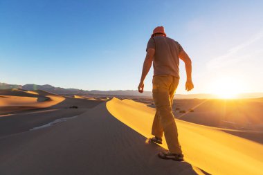 uzun yürüyüşe çıkan kimse Kum Çölü'nde
