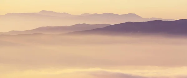 Mountains silhouette in fog — Stock Photo, Image