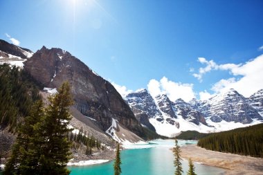 Moraine Gölü 'nün turkuaz suları. Kanada' nın Banff Ulusal Parkı 'nda karla kaplı tepeleri var.