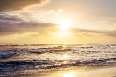 Kumsalda mavi dalga. Bulanık arkaplan ve güneş ışığı lekeleri. Huzurlu doğal arkaplan.