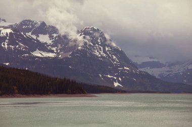 Kanada 'daki dağ gölünün sakin sularındaki kayaların yansımasıyla sakin bir manzara..