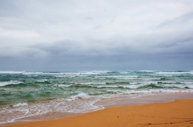 Kumsalda mavi dalga. Bulanık arkaplan ve güneş ışığı lekeleri. Huzurlu doğal arkaplan.